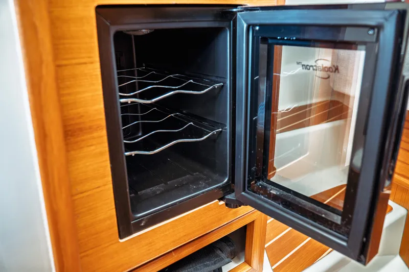 Slide: The Image of 2022 Ranger Tugs R-29 S interior wine cooler with open glass door. - 41