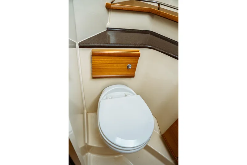 Slide: The Image of 2022 Ranger Tugs R-29 S boat bathroom with toilet and wooden cabinetry. - 43