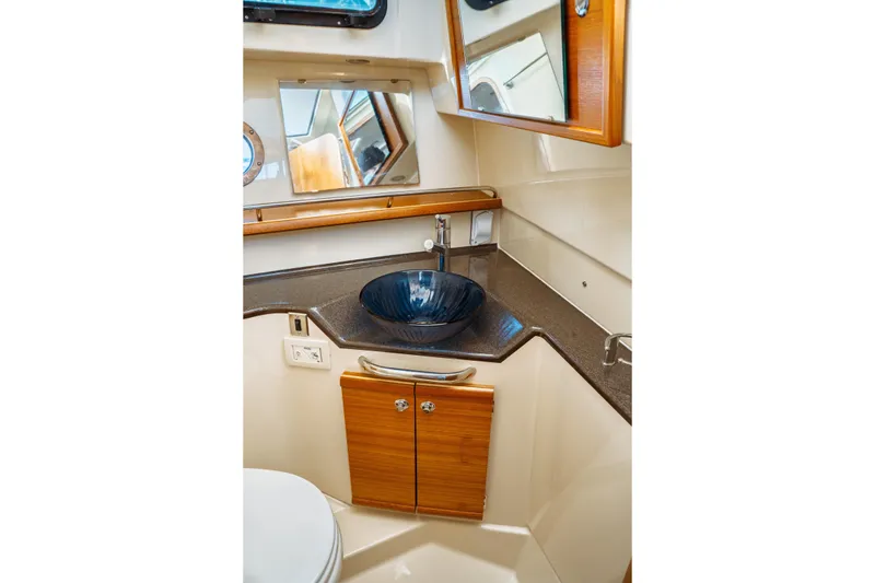 Slide: The Image of 2022 Ranger Tugs R-29 S bathroom with modern sink and wooden cabinetry. - 44