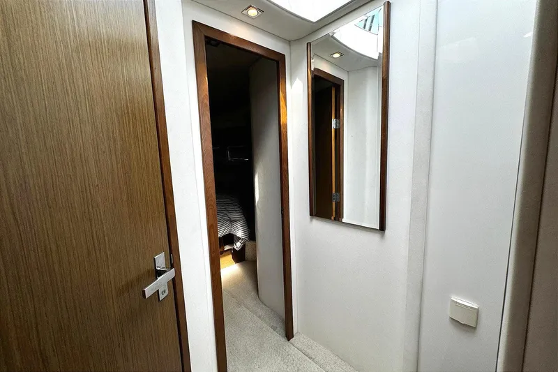 Slide: The Image of Hallway inside 2014 Cruisers Yachts 45 Cantius, featuring wooden doors and a wall mirror. - 19