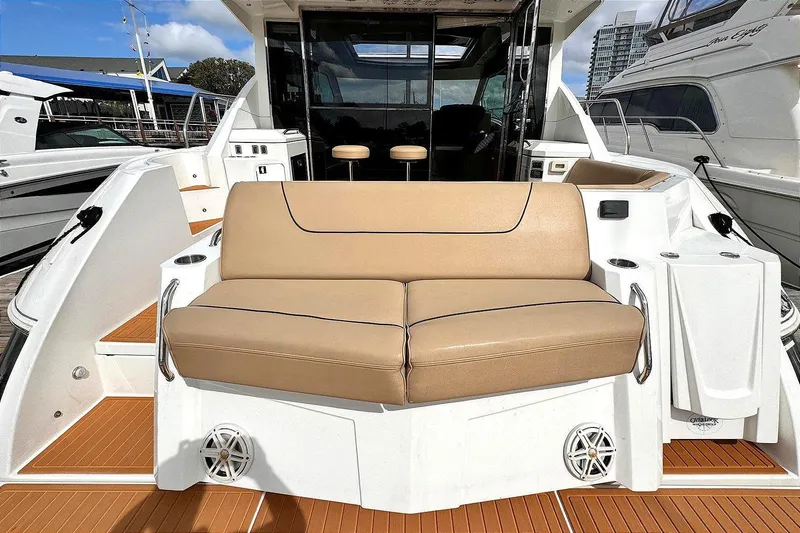 Slide: The Image of 2014 Cruisers Yachts 45 Cantius with tan seating on deck, docked at marina. - 2