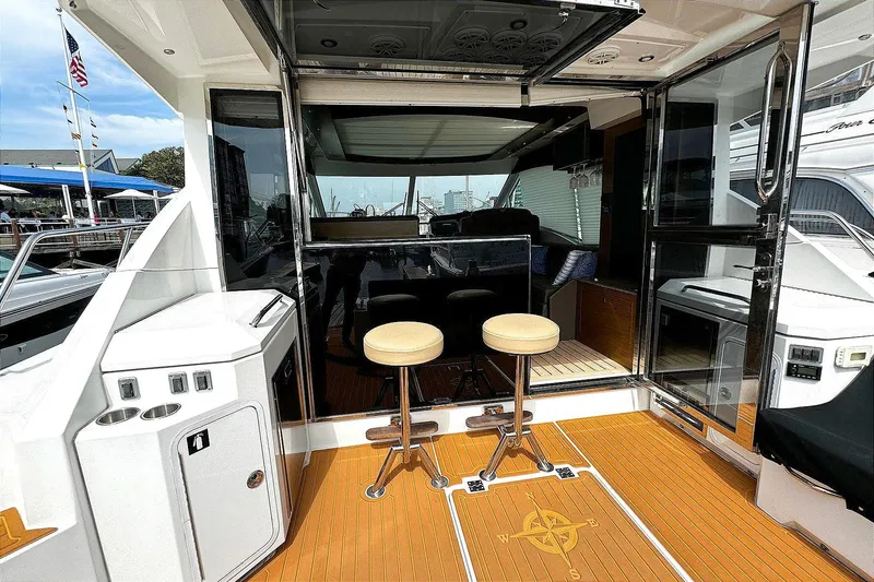 Slide: The Image of 2014 Cruisers Yachts 45 Cantius cockpit with bar stools and open sliding doors. - 5