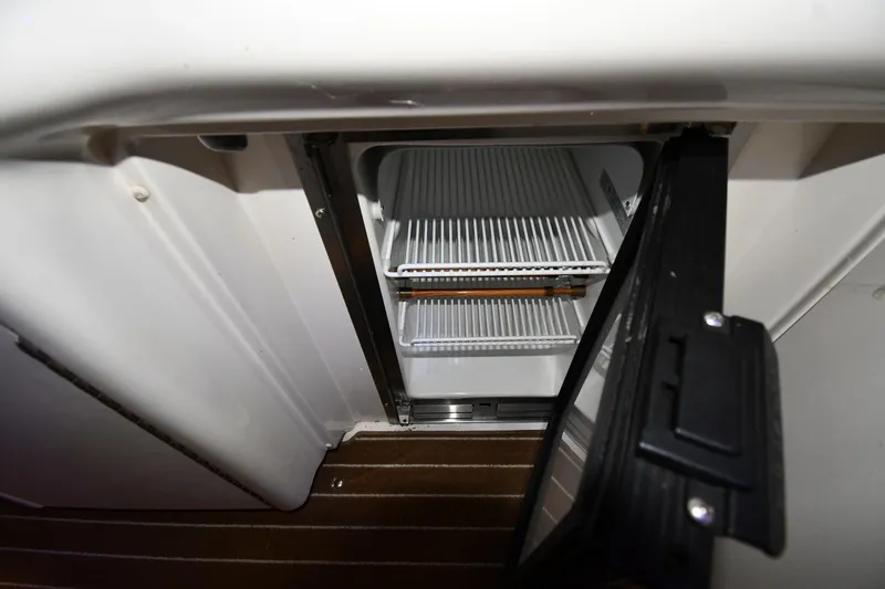 Slide: The Image of Open refrigerator on 2006 Sea Ray 40 Sundancer yacht, showing empty shelves. - 17