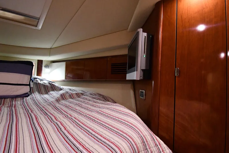 Slide: The Image of Interior cabin of 2006 Sea Ray 40 Sundancer with striped bedding and wooden cabinetry. - 26