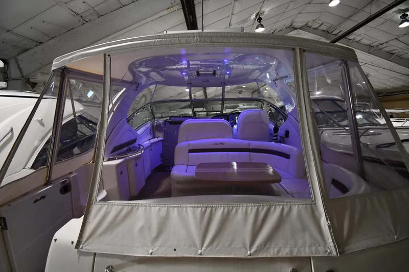 Slide: The Image of 2006 Sea Ray 40 Sundancer interior with seating and table, under soft blue lighting. - 7