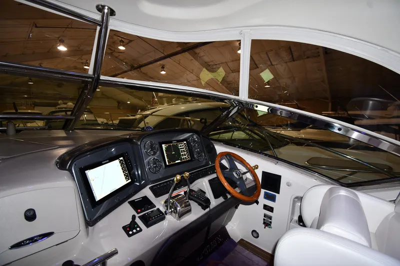 Slide: The Image of 2006 Sea Ray 40 Sundancer helm with modern navigation equipment and wooden steering wheel. - 9