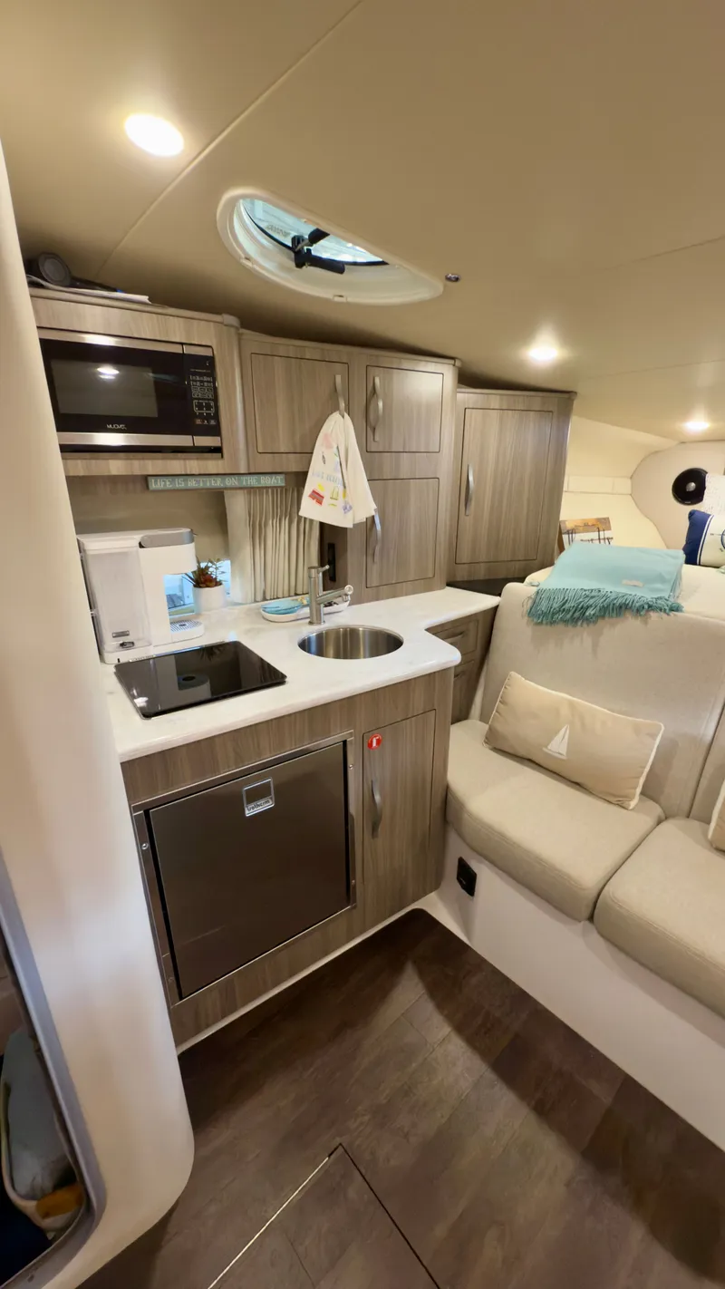 Slide: The Image of 2020 Regal 33 Express yacht interior with modern kitchen and cozy seating area. - 13