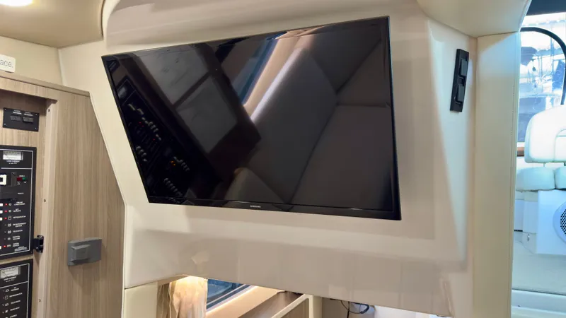 Slide: The Image of Flat-screen TV in 2020 Regal 33 Express yacht interior, featuring modern design and control panel. - 16