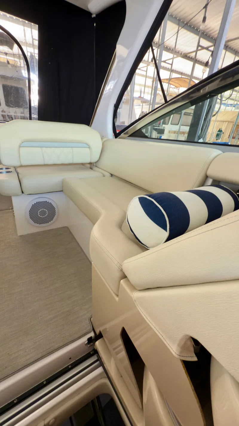 Slide: The Image of 2020 Regal 33 Express interior with beige seating and striped cushion in a boat showroom. - 9