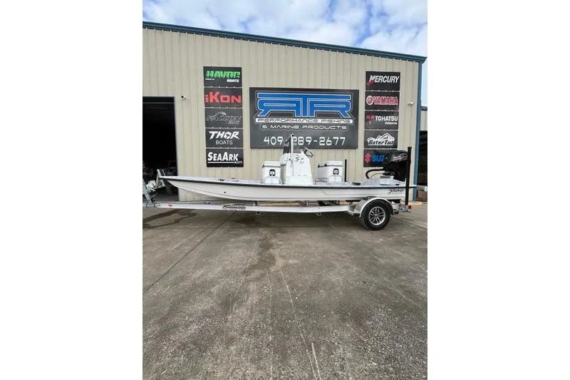 Slide: The Image of 2026 Shoalwater 19 CAT boat on trailer outside marine shop. - 1