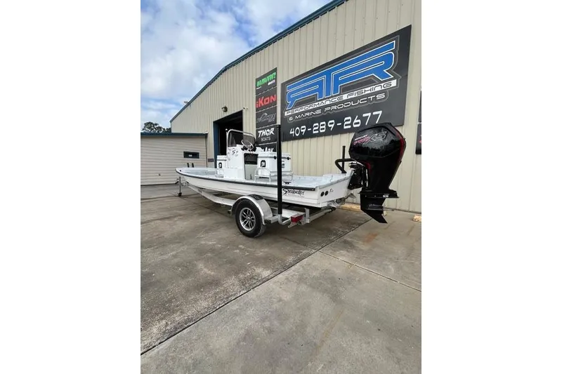 Slide: The Image of 2026 Shoalwater 19 CAT boat on trailer outside marine shop. - 2