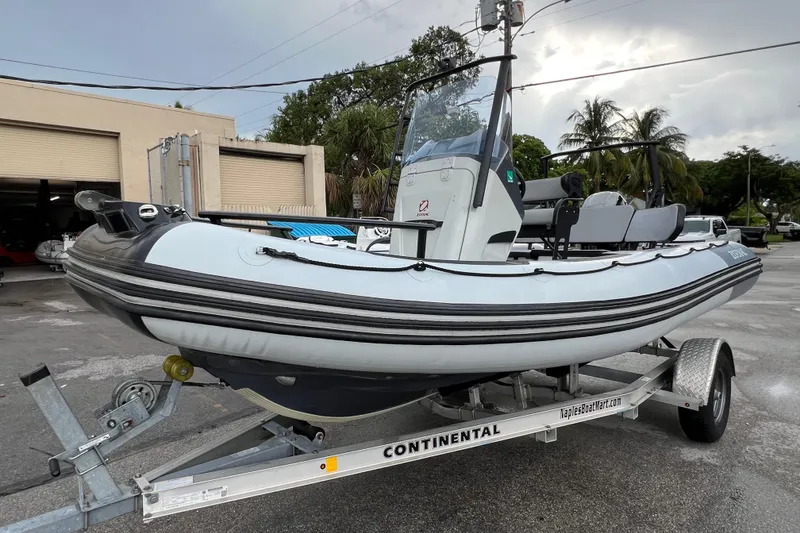 The Image of 2025 Zodiac Open 5.5 boat on trailer, parked outdoors near palm trees. - 0