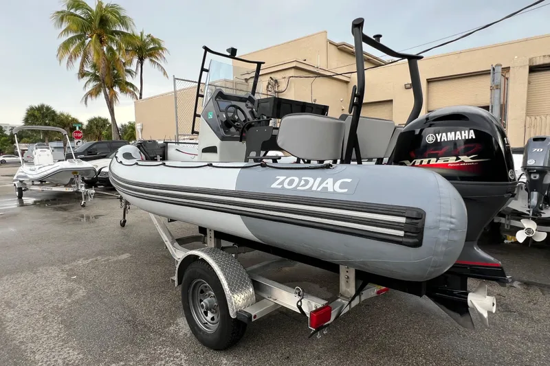 Slide: The Image of 2025 Zodiac Open 5.5 boat on trailer with Yamaha engine, parked outdoors. - 1