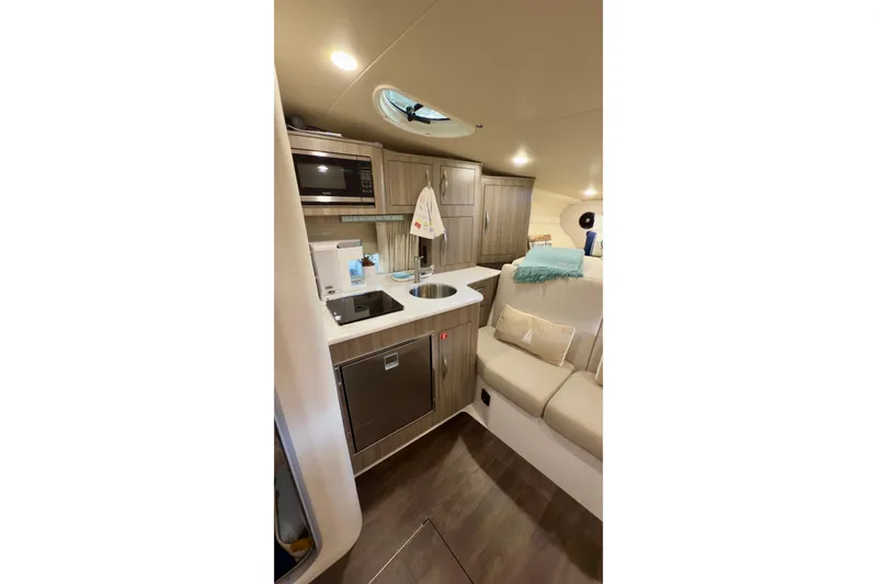 Slide: The Image of 2020 Regal 33 Express yacht interior with kitchenette and seating area. - 14