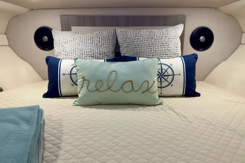 Slide: The Image of Cozy cabin interior of 2020 Regal 33 Express with decorative pillows and bedding. - 16