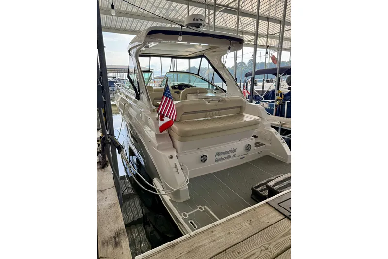 Slide: The Image of 2020 Regal 33 Express boat docked, featuring a spacious seating area and American flag. - 20