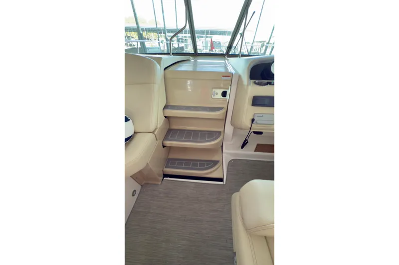 Slide: The Image of Interior view of 2020 Regal 33 Express boat, featuring beige seating and steps. - 6