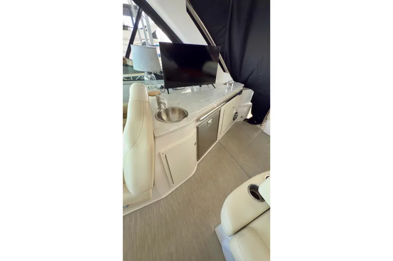 Slide: The Image of 2020 Regal 33 Express yacht interior with TV, sink, and seating area. - 8