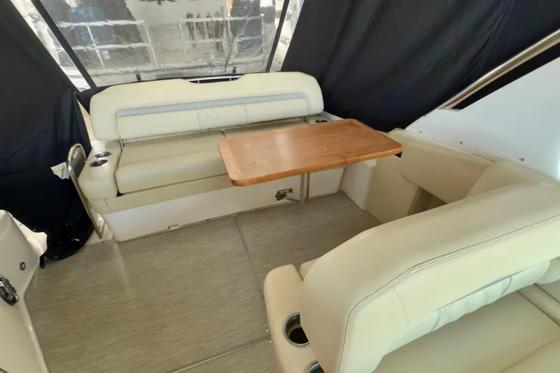 Slide: The Image of 2020 Regal 33 Express boat interior with beige seating and wooden table. - 9