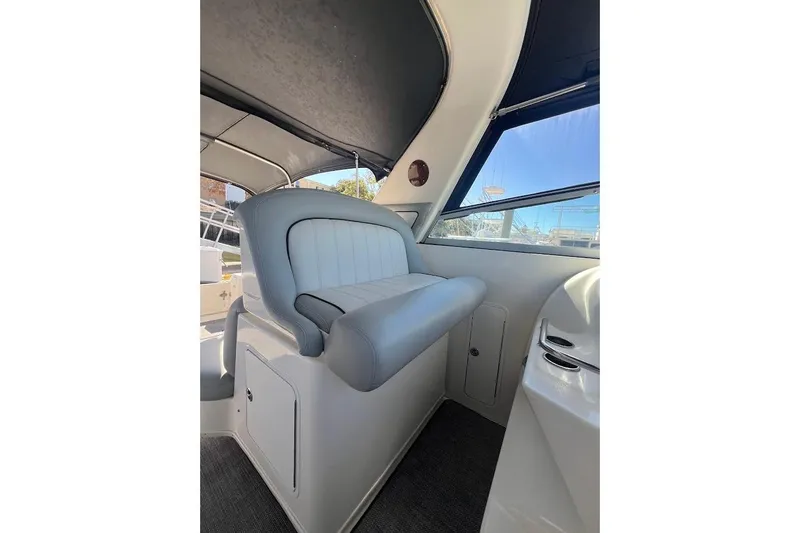 Slide: The Image of Interior of 1997 Sea Ray 330 Express boat with cushioned seating and window view. - 10