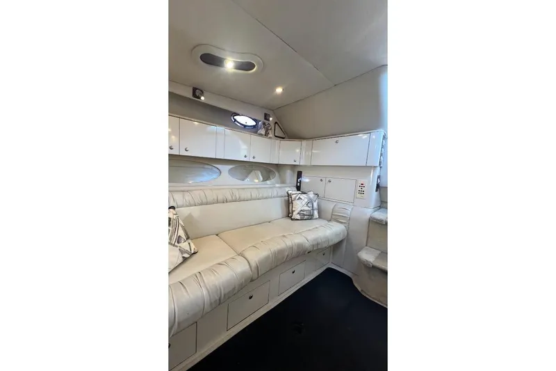 Slide: The Image of Interior of 1997 Sea Ray 330 Express with white seating and storage cabinets. - 15