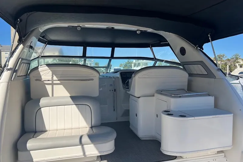 Slide: The Image of 1997 Sea Ray 330 Express boat interior with seating and helm, under a canopy. - 3