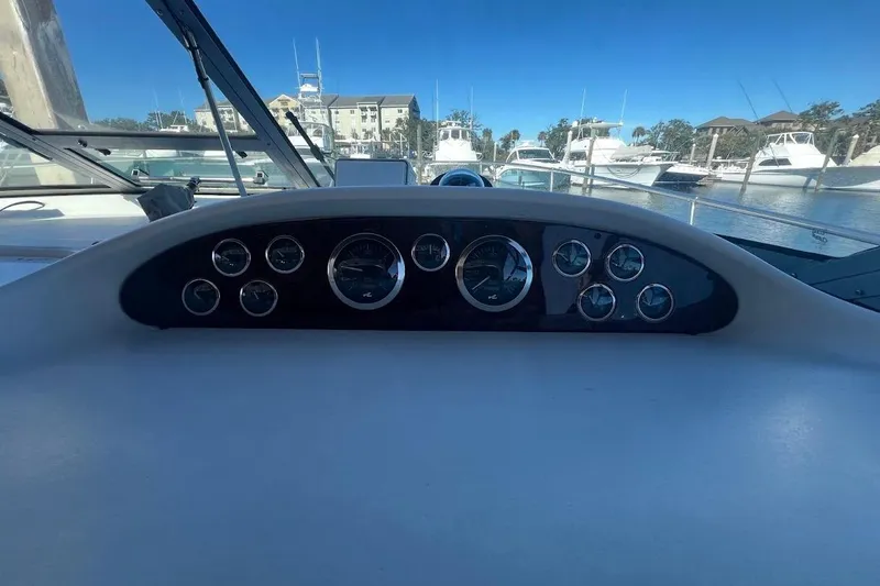 Slide: The Image of 1997 Sea Ray 330 Express dashboard with gauges, docked at marina. - 6