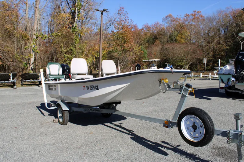 Slide: The Image of 2015 Carolina Skiff J14 CC boat on trailer, parked outdoors with autumn trees in background. - 7