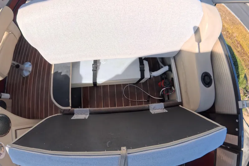 Slide: The Image of 2018 Crest I 220 SLC boat interior with beige seating and wood-style flooring. - 10