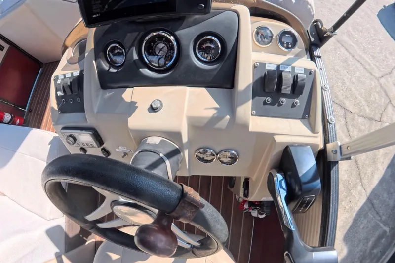 Slide: The Image of 2018 Crest I 220 SLC boat interior with steering wheel and control panel. - 15