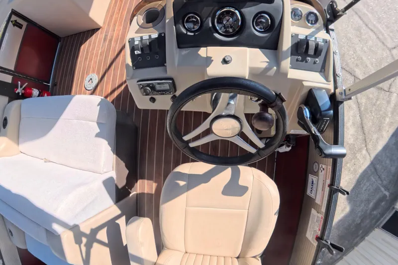Slide: The Image of 2018 Crest I 220 SLC boat interior with beige seating and wood flooring. - 16