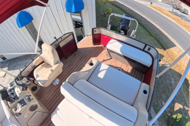 Slide: The Image of 2018 Crest I 220 SLC boat interior showing storage compartment with secured white container. - 18