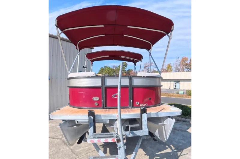 Slide: The Image of 2018 Crest I 220 SLC pontoon boat with red canopy and silver accents on a trailer. - 4