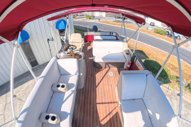 Slide: The Image of 2018 Crest I 220 SLC boat interior with beige seating and wood-style flooring. - 7