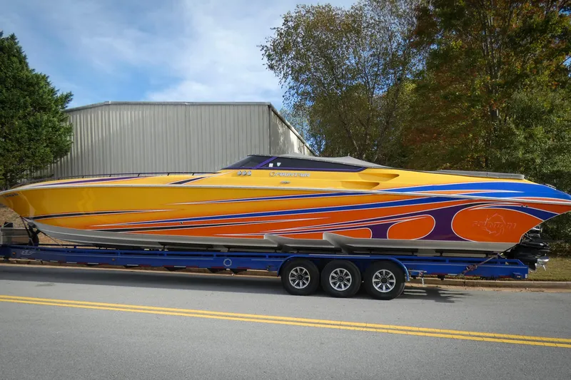 The Image of 2006 Fountain 47 Lightning speedboat on trailer, vibrant yellow and orange design. - 0