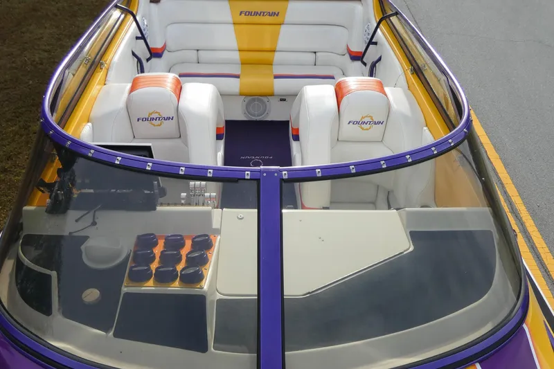 Slide: The Image of 2006 Fountain 47 Lightning boat interior with white and orange seating, purple trim, and dashboard controls. - 6