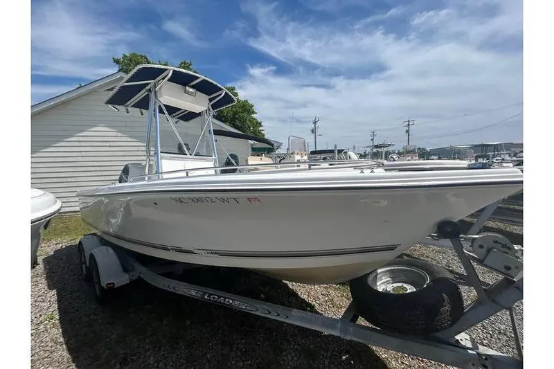 Slide: The Image of 2002 Sailfish 216 CC boat on trailer, parked outdoors under a clear sky. - 1