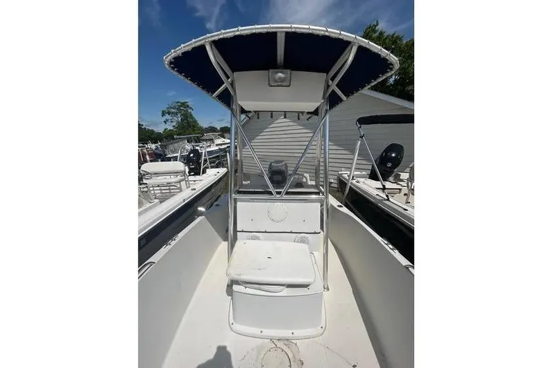 Slide: The Image of 2002 Sailfish 216 CC boat with T-top and center console, docked outdoors. - 3