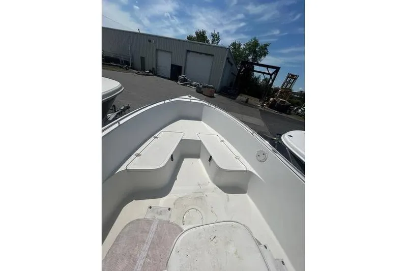 Slide: The Image of 2002 Sailfish 216 CC boat interior with seating, docked outdoors under blue sky. - 4