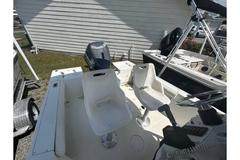 Slide: The Image of 2002 Sailfish 216 CC boat interior with dual white seats and steering console. - 7