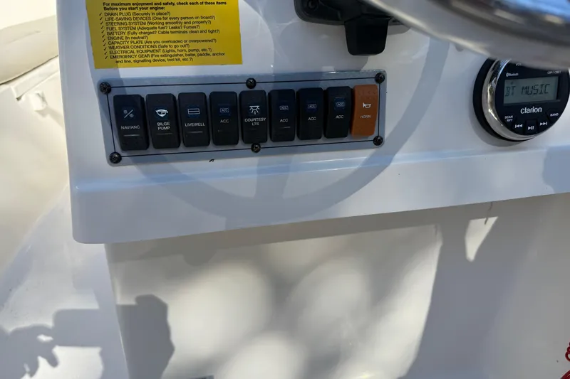 Slide: The Image of Control panel of 2023 Key West 203 DFS boat with switches and Clarion audio system. - 11