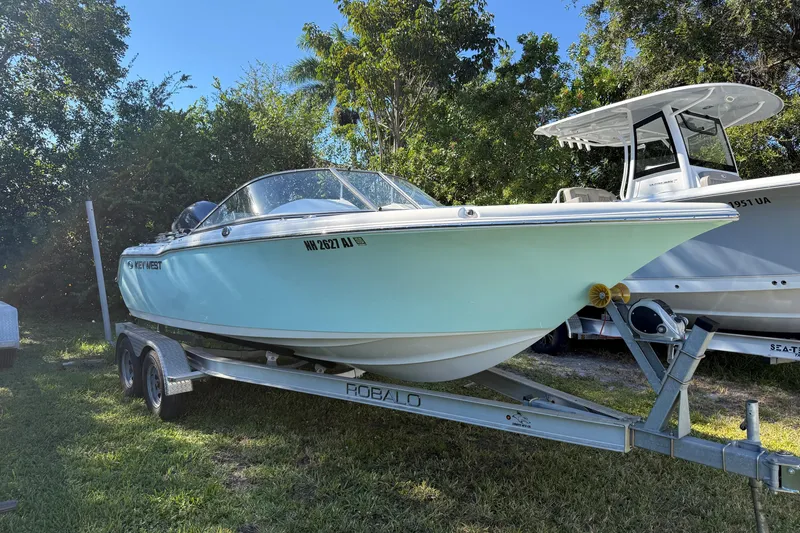 Slide: The Image of 2023 Key West 203 DFS boat on trailer, parked outdoors. - 2