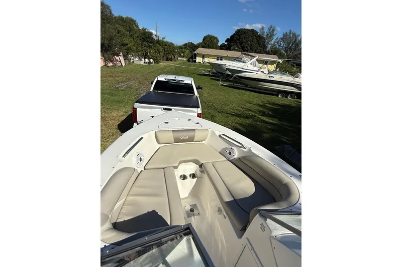 Slide: The Image of 2023 Key West 203 DFS boat interior with beige seating, parked on grass. - 5