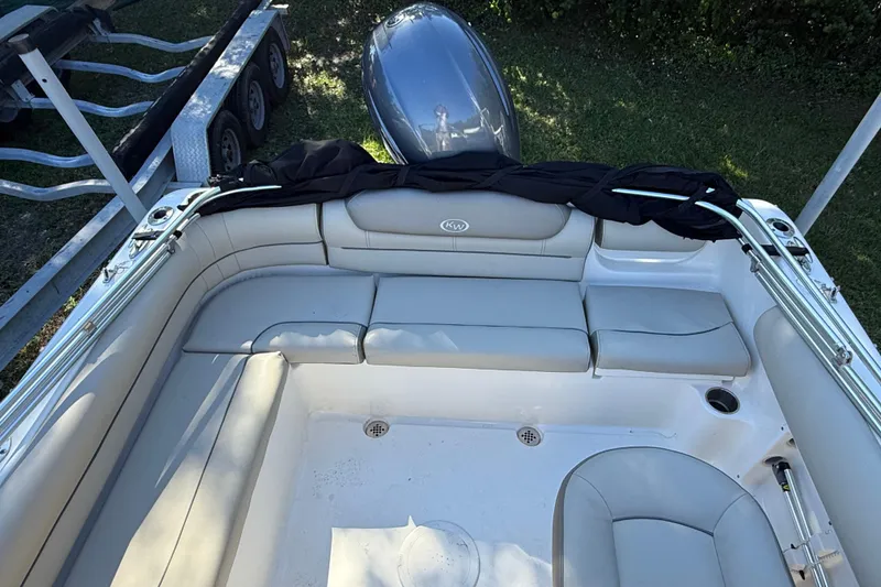Slide: The Image of 2023 Key West 203 DFS boat interior with cushioned seating and motor view. - 6