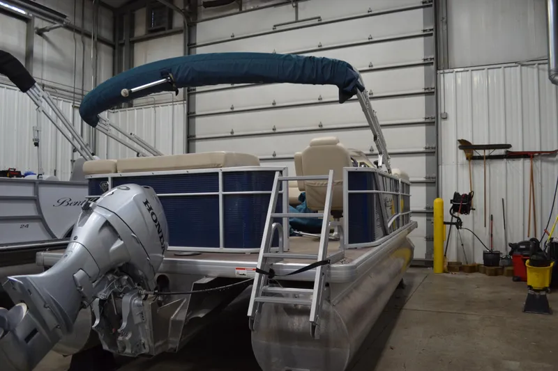 Slide: The Image of 2018 Sweetwater SW2086c pontoon boat with Honda motor in a storage facility. - 2