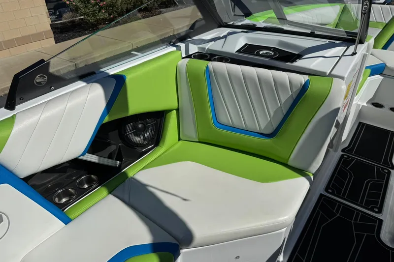 Slide: The Image of 2022 Tigé 20RZX boat interior with green and white seating, cup holders, and speaker. - 10