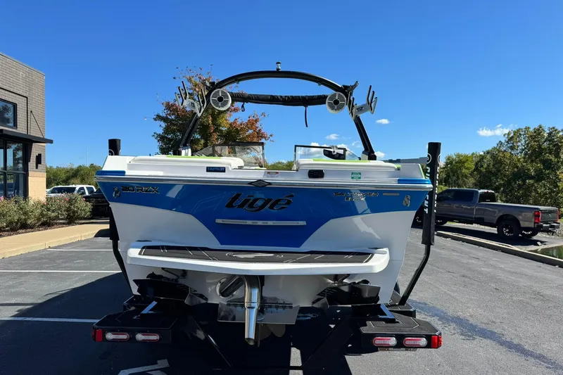 Slide: The Image of 2022 Tigé 20RZX boat, blue and white, parked outdoors on a sunny day. - 4