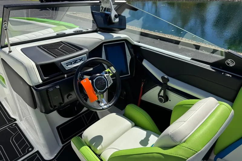 Slide: The Image of 2022 Tigé 20RZX boat interior with green and white seating, modern dashboard, and steering wheel. - 9