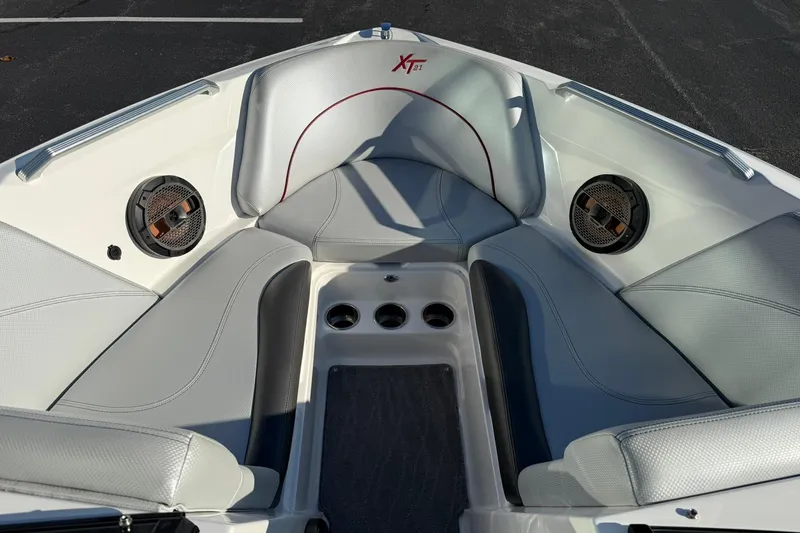 Slide: The Image of 2018 MasterCraft XT21 boat interior with gray seating and built-in speakers. - 10
