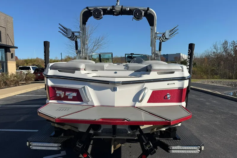 Slide: The Image of 2018 MasterCraft XT21 boat, rear view, parked outdoors on a sunny day. - 4
